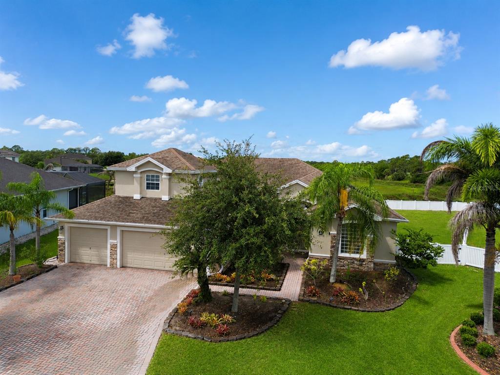 An aerial view of a two-story suburban house with a brick driveway and palm trees — 197 BRANDY CREEK CIRCLE SE, PALM BAY, FL