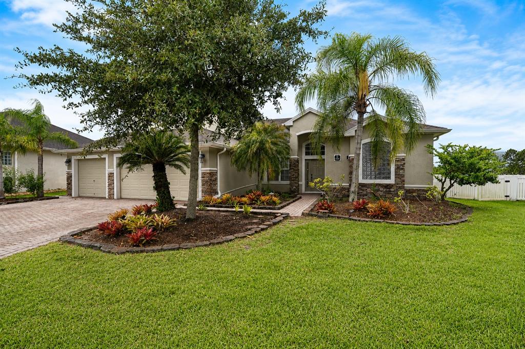 A single-story house with a paved driveway, palm trees, and a landscaped front yard — 197 BRANDY CREEK CIRCLE SE, PALM BAY, FL