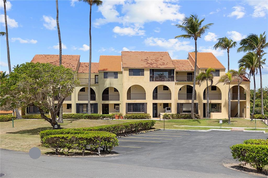 An entryway features wood-look cabinets, a black paneled door, and light-colored square floor tiles — DR BEACH VILLAGE UNIT 119, HUMACAO, PR