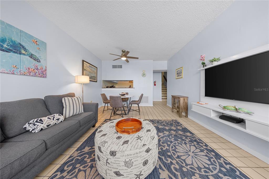 A living and dining area with tile floors, a ceiling fan, and a blue rug — DR BEACH VILLAGE UNIT 119, HUMACAO, PR