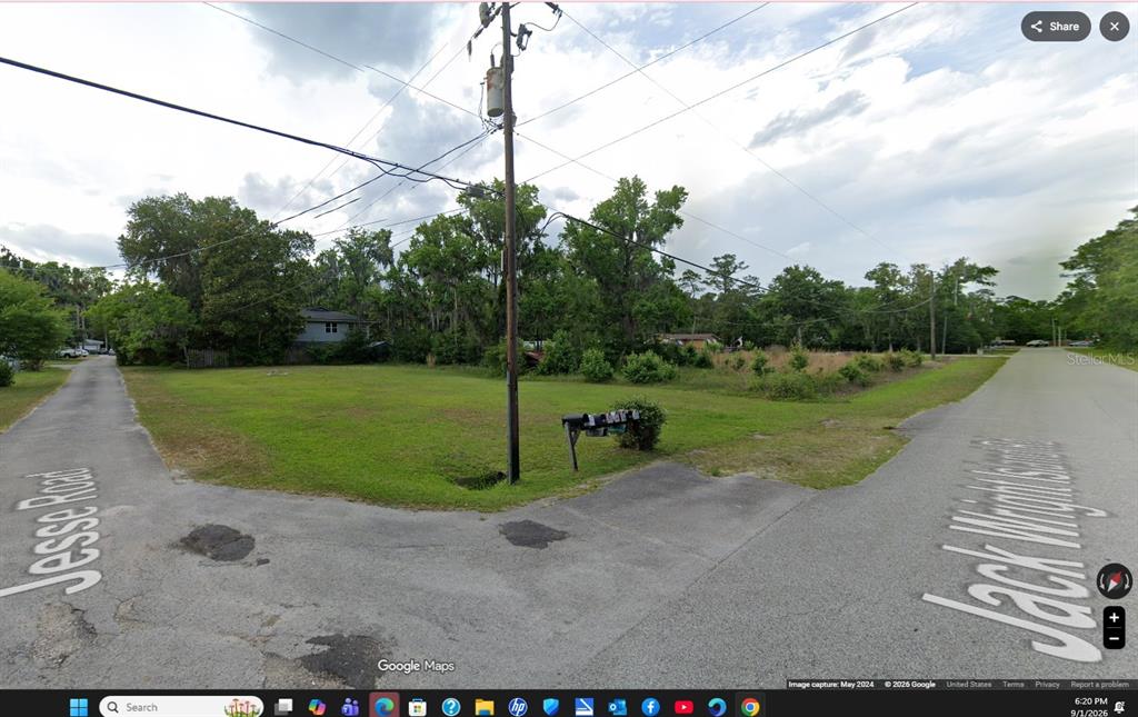 An empty, grassy corner lot sits at the intersection of two paved residential roads — 110 JESSE ROAD, ST AUGUSTINE, FL