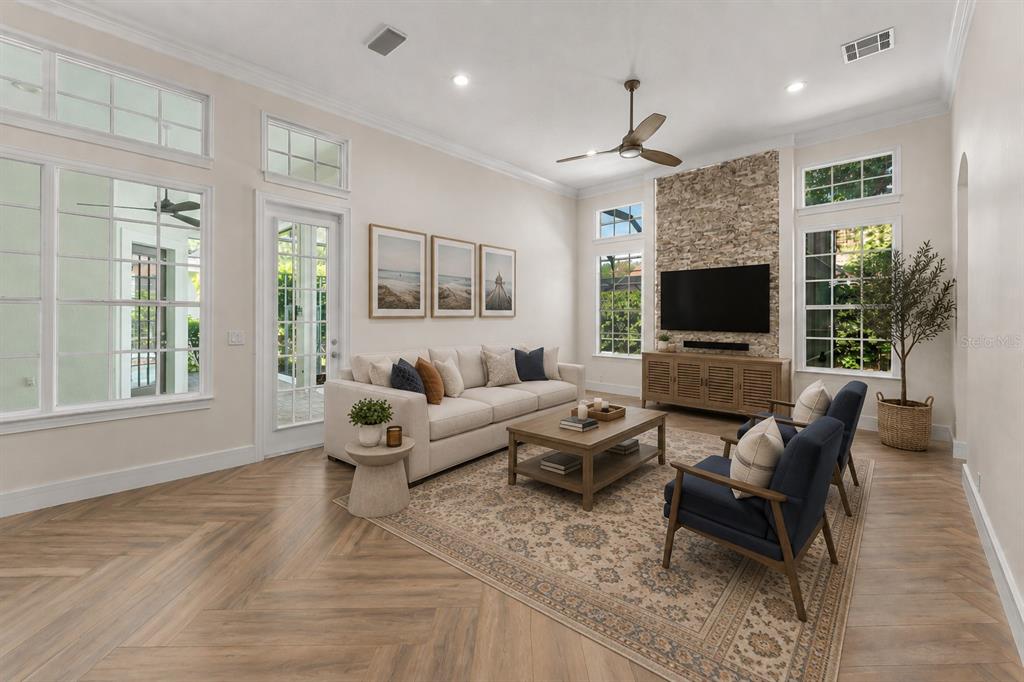 A living room features a stone fireplace, herringbone wood floors, and a neutral sofa — 8351 BOWDEN WAY, WINDERMERE, FL