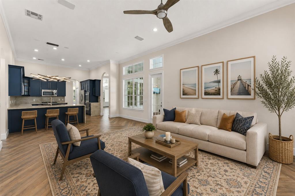 A living room with blue cabinets, a kitchen island, and a beige sofa on a rug — 8351 BOWDEN WAY, WINDERMERE, FL