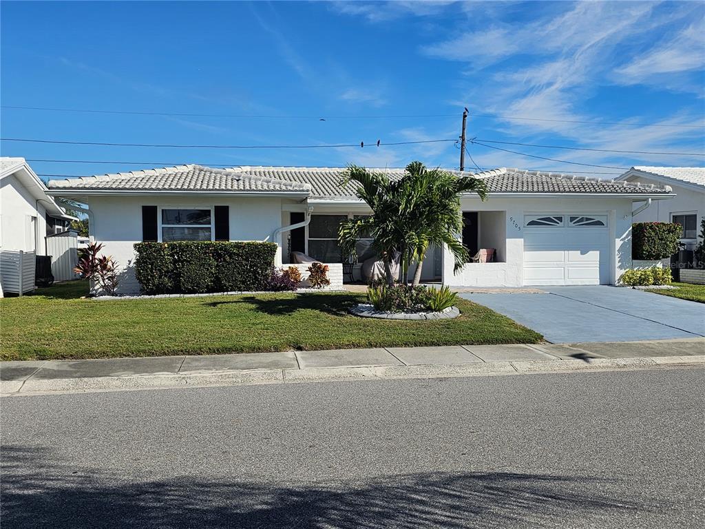A single-story white house with a tile roof, a palm tree, and a garage — 9705 MAINLANDS BOULEVARD W, PINELLAS PARK, FL