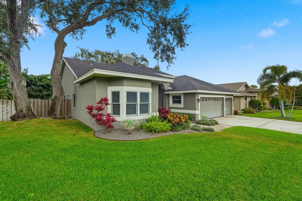 A single-story house with a gray exterior, a two-car garage, and a large front lawn — 700 WESTFIELD COURT, DUNEDIN, FL