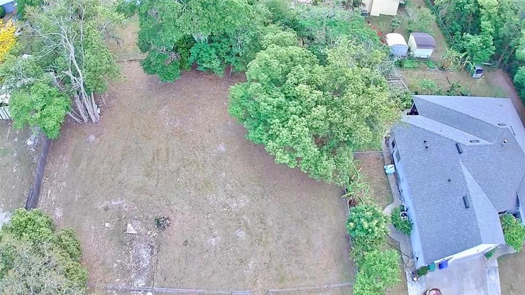 An aerial view shows a large, grassy backyard with mature trees and a residential house — 139 N HOLLIS STREET, LAKE MARY, FL