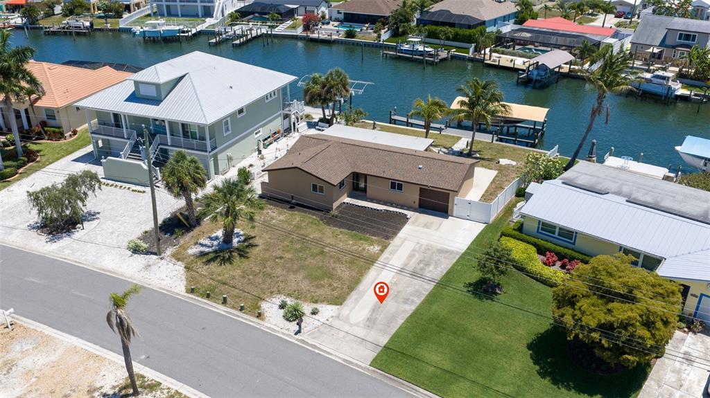 An aerial view shows a house with a brown roof, a boat dock, and waterfront access — 5108 COMMONWEALTH ROAD, PALMETTO, FL