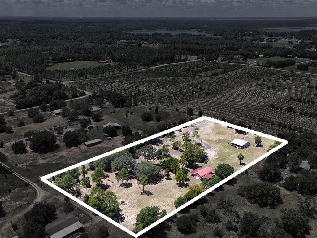 An aerial view shows a rectangular property lot containing two houses and scattered trees — 37647 JENNY LANE, EUSTIS, FL