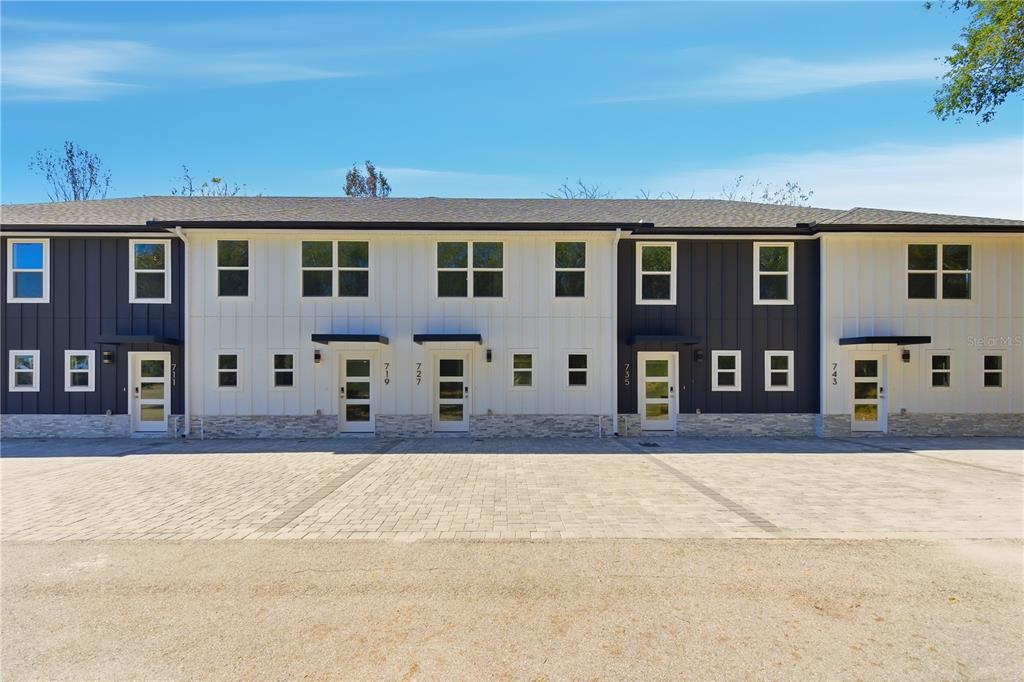 A two-story townhouse complex features a mix of dark and white vertical siding — 727 CLEMSON DRIVE, ALTAMONTE SPRINGS, FL