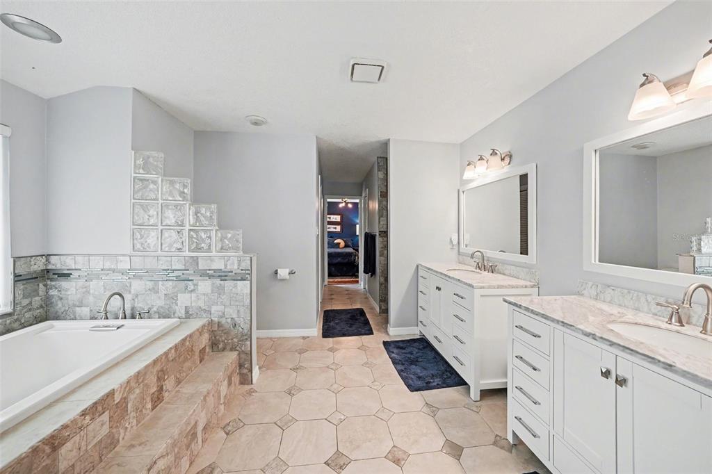 An aerial view shows a single-story house with a stone facade and a concrete driveway — 1009 MORFIELD LANE, BRANDON, FL