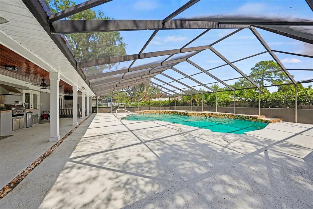 An aerial view of a house with a stone facade, shingled roof, and concrete driveway — 1009 MORFIELD LANE, BRANDON, FL