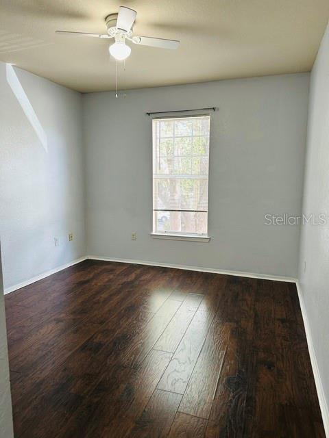 A bathroom features a dark wood vanity with a granite countertop and a toilet — 126 VISTA VERDI CIRCLE UNIT 204, LAKE MARY, FL