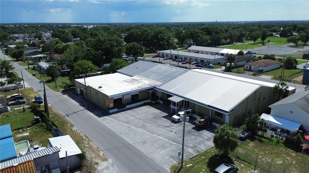An aerial view shows a commercial warehouse building with a large paved parking lot — 936 EDITH AVENUE, LAKELAND, FL
