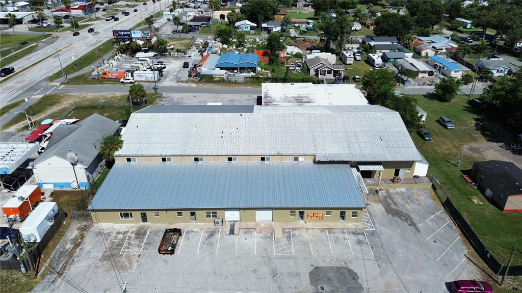 An aerial view shows a large commercial building with a metal roof and parking lot — 936 EDITH AVENUE, LAKELAND, FL
