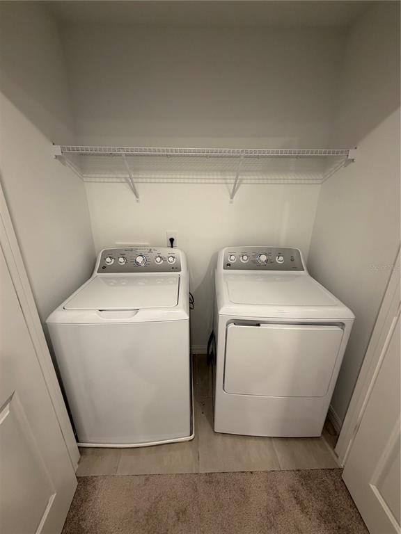 A laundry closet containing a white top-loading washing machine and a matching dryer — 4870 SPANGLE DRIVE, ST CLOUD, FL