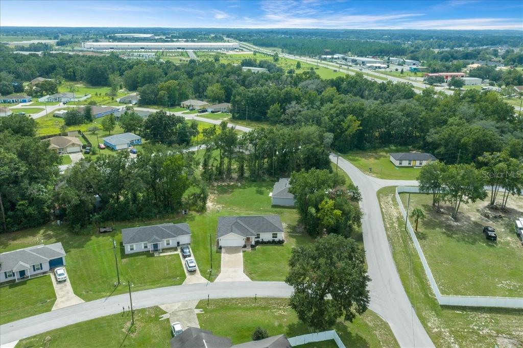 An aerial view shows several single-family homes surrounded by trees and grassy lots — 2 DOGWOOD DRIVE RADL., OCALA, FL