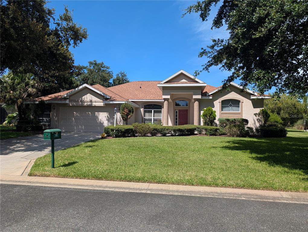 A grassy backyard overlooks a wooded area under a clear blue sky — 1315 ELLI CIRCLE, ORMOND BEACH, FL