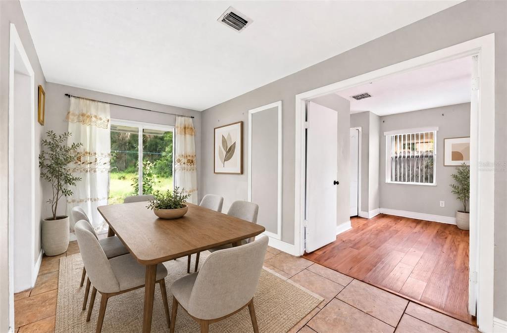 A dining room with a wooden table, light-colored chairs, and tile flooring leads to another room — 6045 WEDGEWOOD CIRCLE, ORLANDO, FL