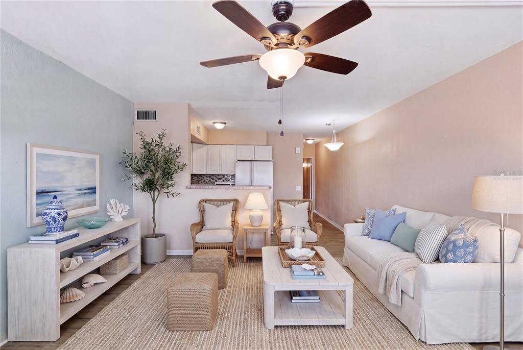 A living room features a white sofa, two wicker chairs, and a coffee table — 4325 58TH WAY N UNIT 1525, KENNETH CITY, FL