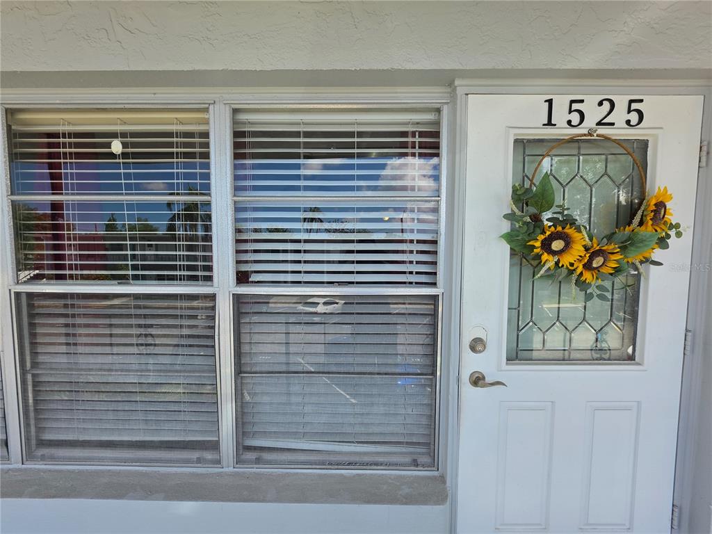 A white front door with a sunflower wreath and a large window with blinds — 4325 58TH WAY N UNIT 1525, KENNETH CITY, FL