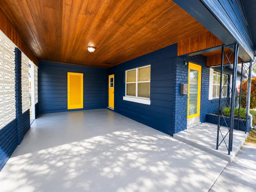 A covered porch with a wood ceiling, blue siding, and bright yellow doors — 501 AVENUE G SE, WINTER HAVEN, FL