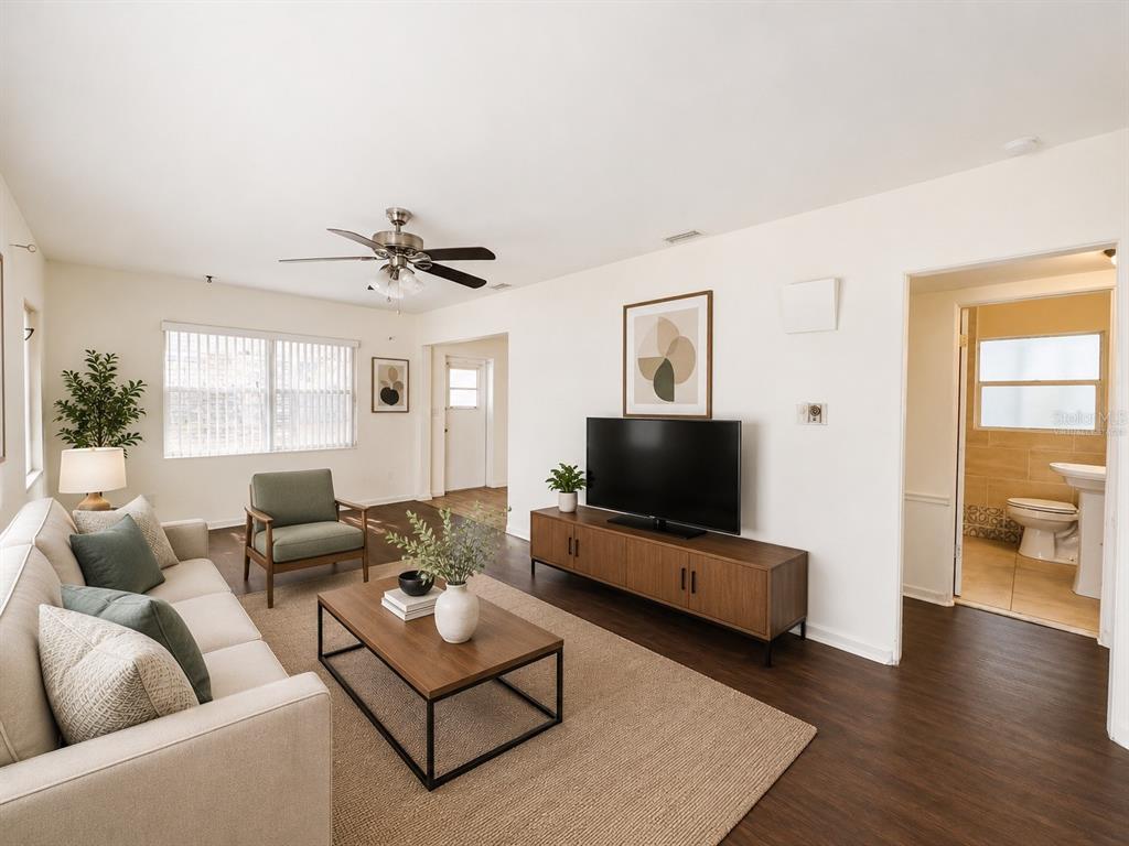 A living room features a sofa, armchair, coffee table, television, and an adjacent bathroom — 501 AVENUE G SE, WINTER HAVEN, FL
