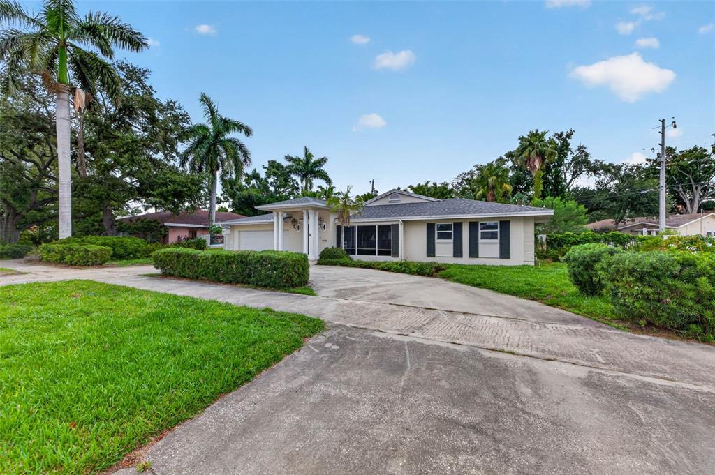 A single-story house with a concrete driveway, palm trees, and a manicured lawn — 201 SNELL ISLE BOULEVARD NE, ST PETERSBURG, FL