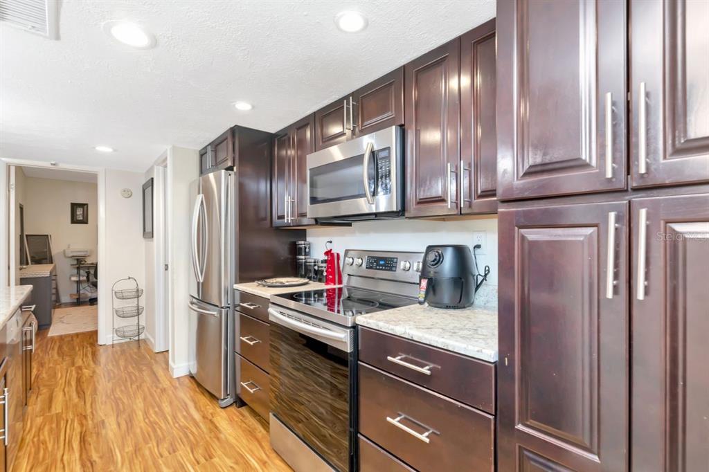 An entryway with wood-look flooring, a white door, and a black wall-mounted coat rack — 3765 41ST STREET S UNIT K, ST PETERSBURG, FL