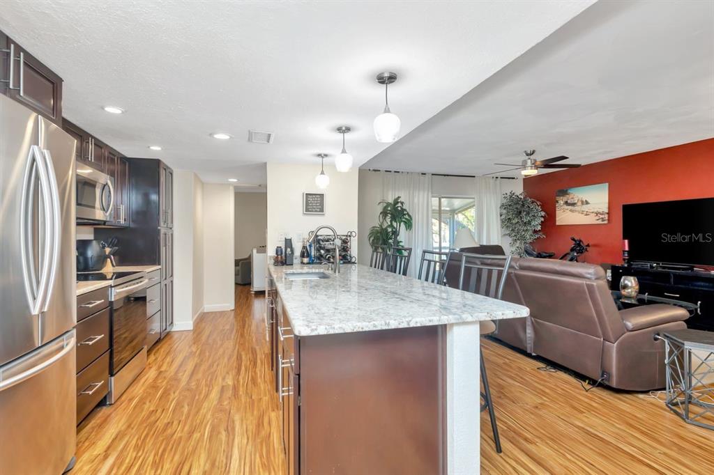 A kitchen features dark wood cabinets, stainless steel appliances, and light-colored granite countertops — 3765 41ST STREET S UNIT K, ST PETERSBURG, FL