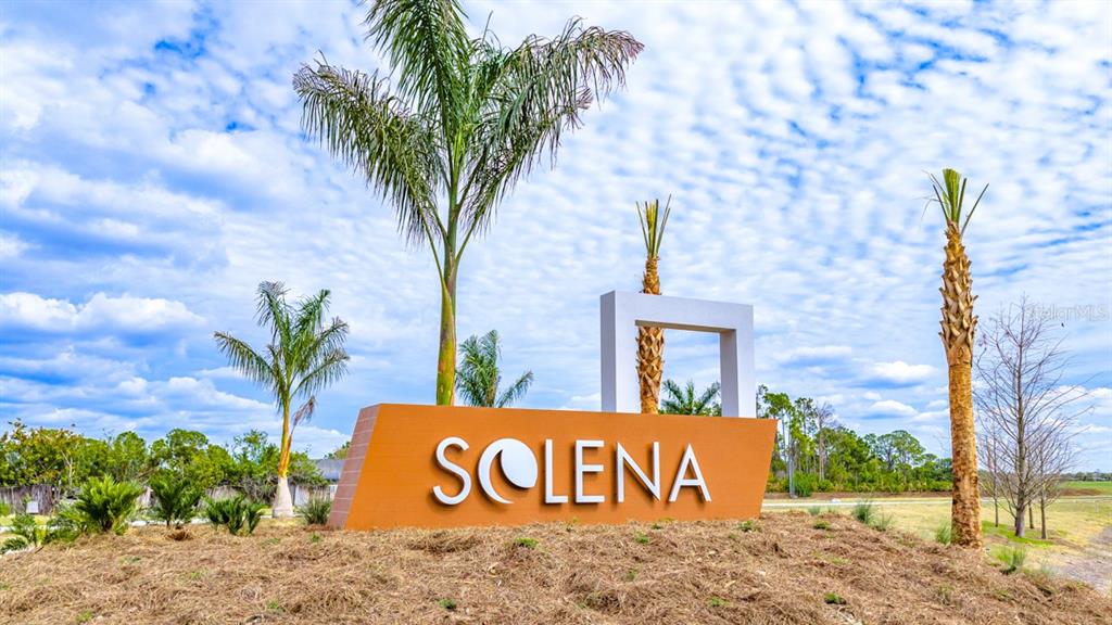 A large orange sign reading Solena stands in a landscaped area with palm trees — 6778 EQUINOX LANE, NORTH FORT MYERS, FL