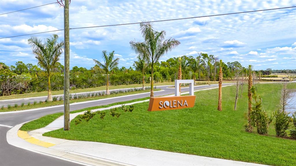 A sign reading Solena stands on a grassy lawn near a road and palm trees — 6778 EQUINOX LANE, NORTH FORT MYERS, FL