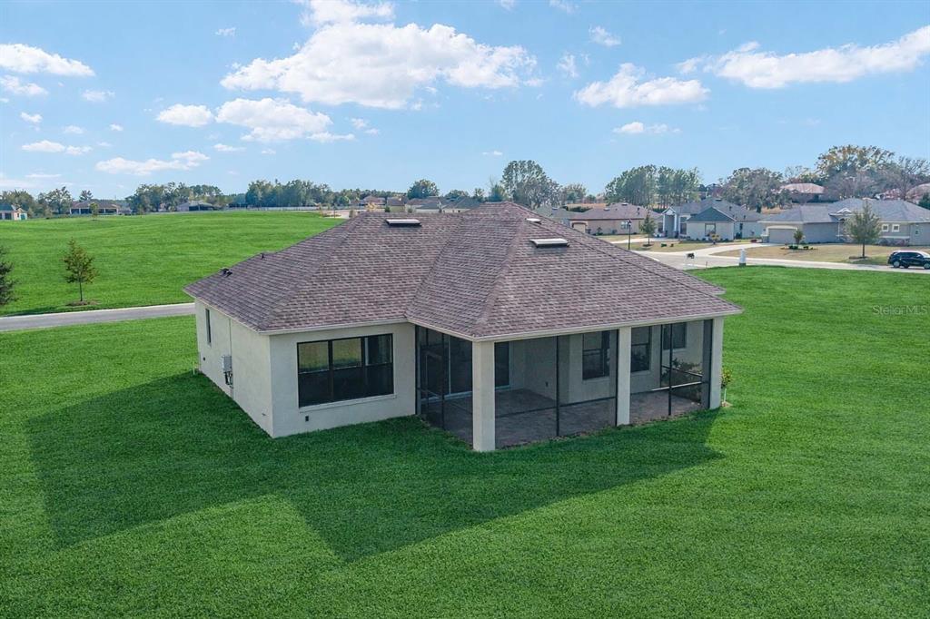 An aerial view of a single-story house with a screened-in patio and large grassy yard — 1499 E PEGASUS LANE, INVERNESS, FL