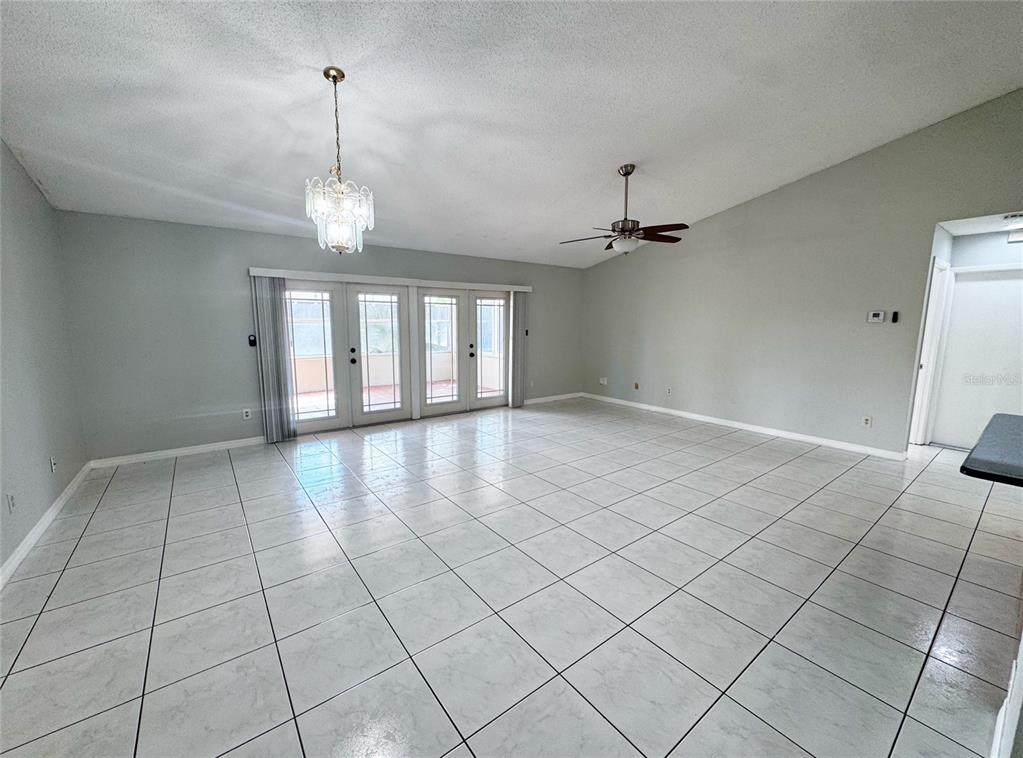 A tiled hallway leads to a living area with glass doors and a stainless refrigerator — 12225 PANTAR STREET, ORLANDO, FL