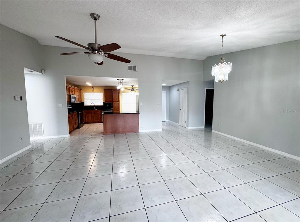 A spacious room with light-colored tile flooring, a ceiling fan, and glass patio doors — 12225 PANTAR STREET, ORLANDO, FL