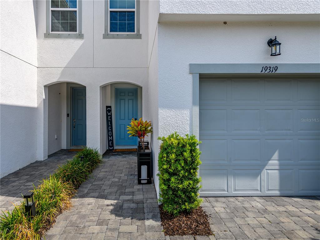 A modern kitchen features light gray cabinets, a large white island, and stainless steel appliances — 19319 BLUE POND DRIVE UNIT 22, LUTZ, FL