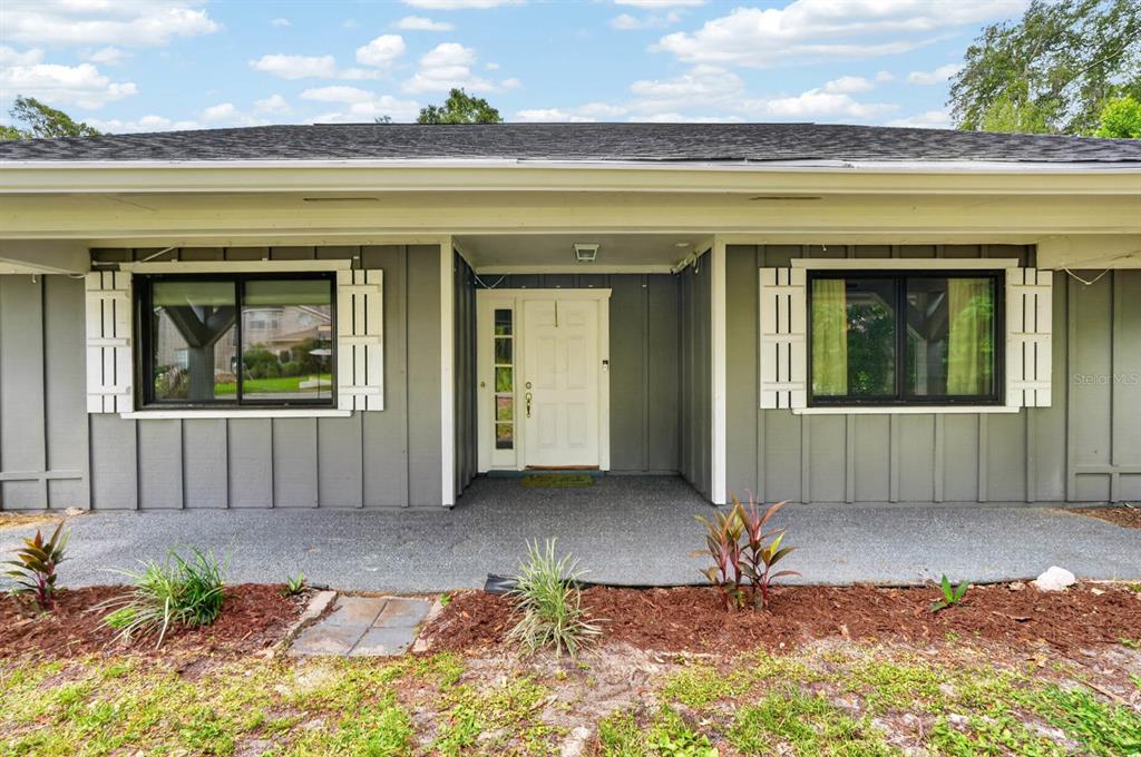 An entryway with a white front door leads into a dining room with tiled floors — 11 RIO PINAR TRAIL, ORMOND BEACH, FL