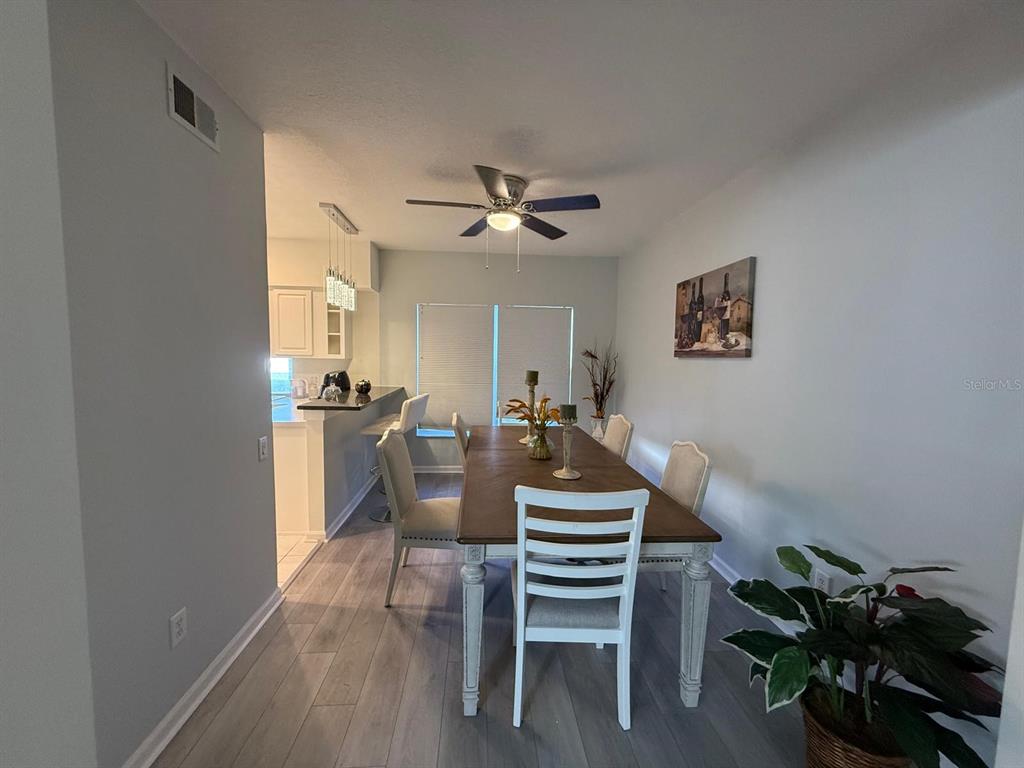 A dining room features a wooden table with white chairs, light flooring, and a ceiling fan — 424 FLATWOOD DRIVE, WINTER SPRINGS, FL