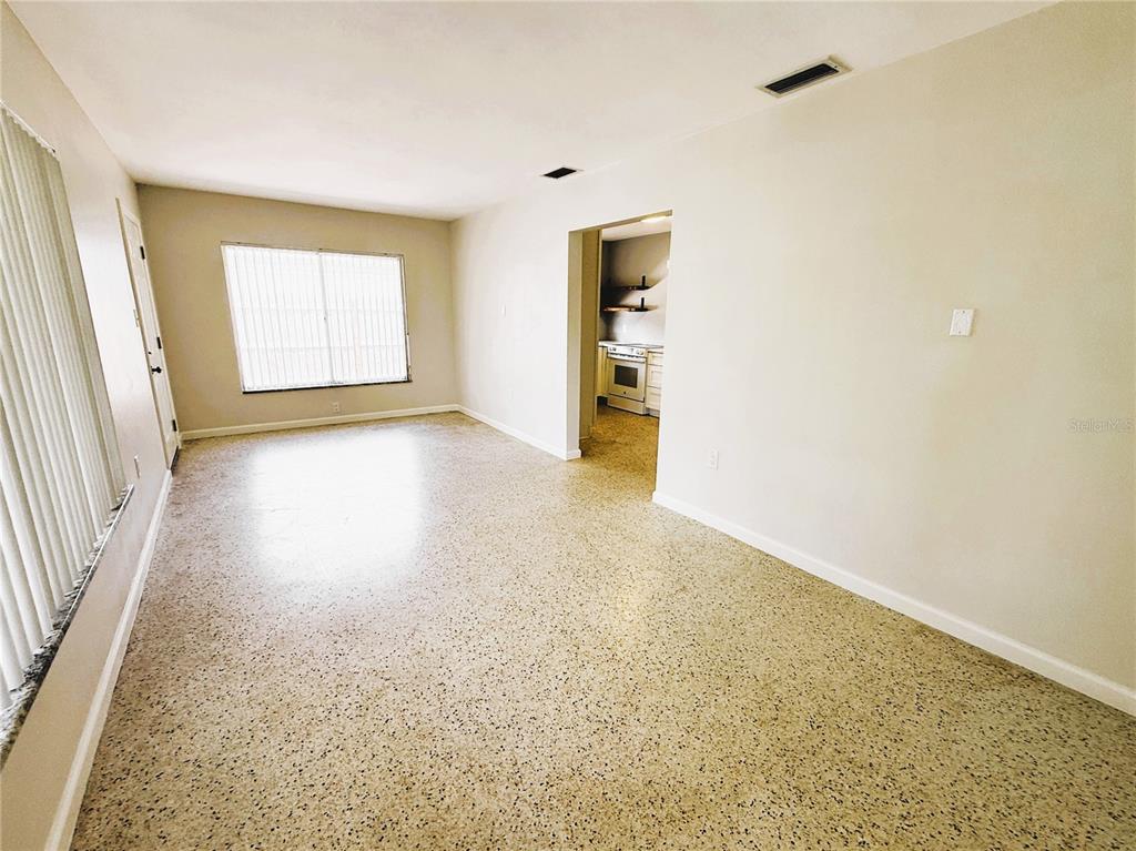 A room with light-colored walls, terrazzo flooring, two windows with vertical blinds, and a desk — 14017 W PARSLEY DRIVE, MADEIRA BEACH, FL