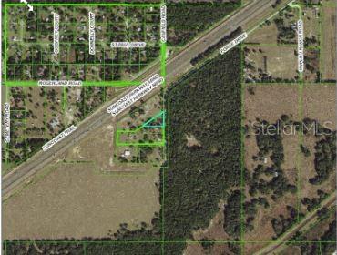 This is an aerial map showing a property parcel outlined in green near a highway — FORGE DRIVE, SPRING HILL, FL