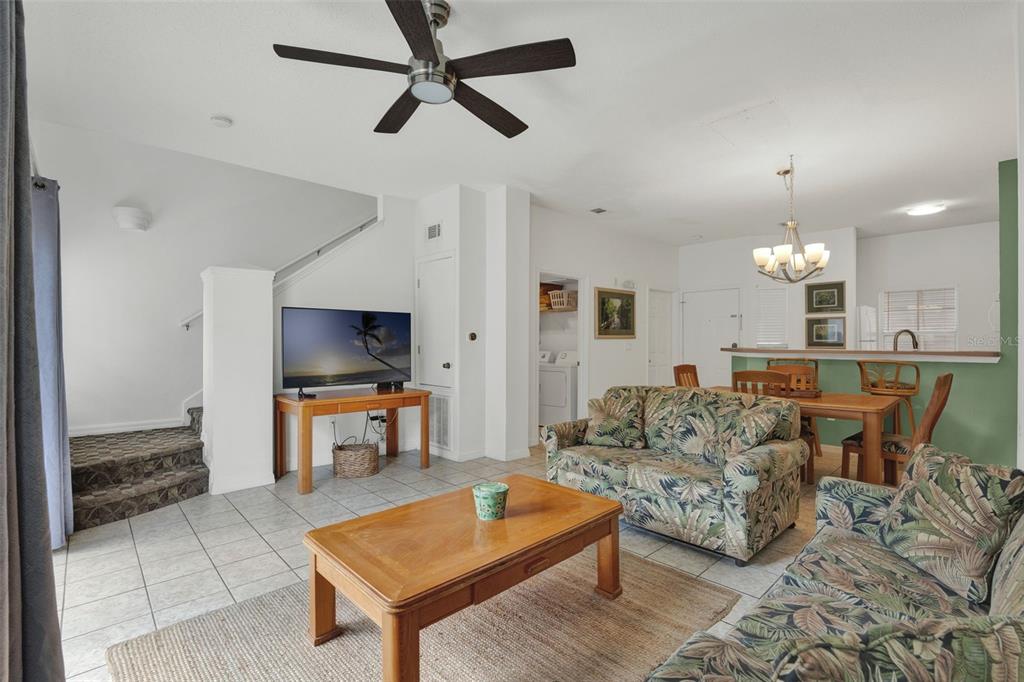 A living room and dining area feature tile floors, a green accent wall, and floral sofas — 1086 PARK RIDGE CIRCLE, KISSIMMEE, FL