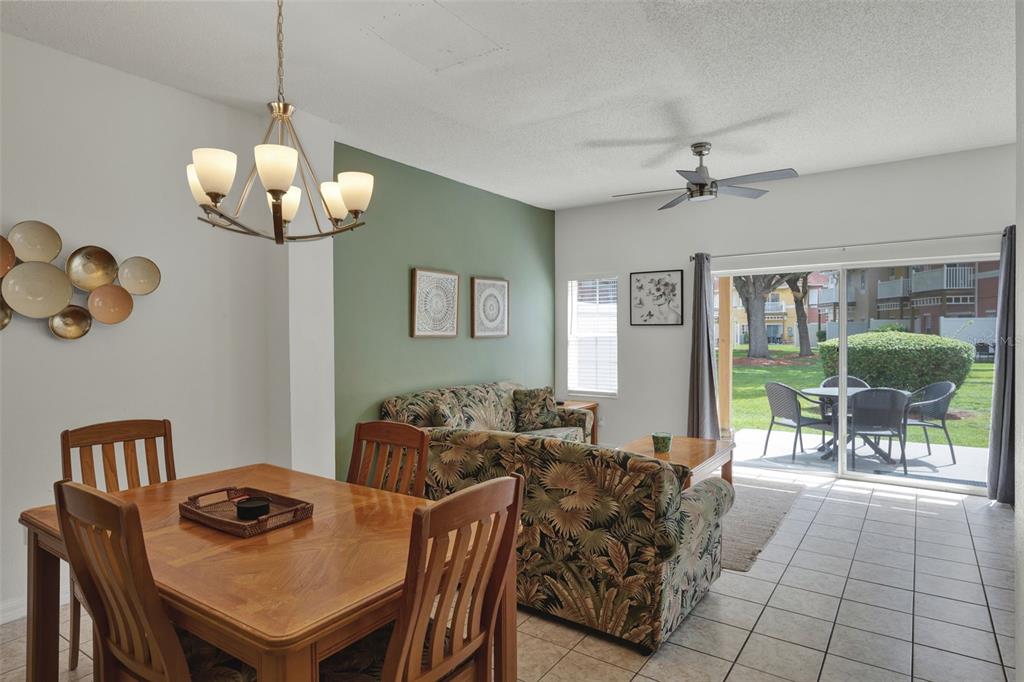 A living room with tile floors, tropical-print furniture, a wooden coffee table, and a ceiling fan — 1086 PARK RIDGE CIRCLE, KISSIMMEE, FL
