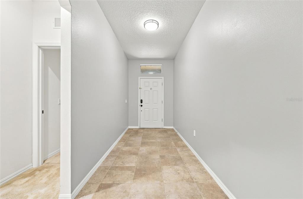 A living room with wood-look flooring, light gray walls, and a ceiling fan — 192 BLACKSTONE CREEK ROAD, GROVELAND, FL