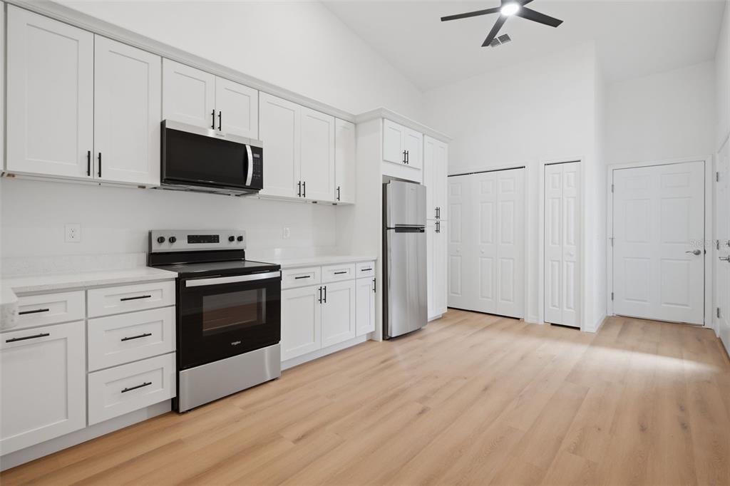 This is a rendering of an open-concept living and dining room with light wood floors — 1411 OAK PL UNIT B, APOPKA, FL