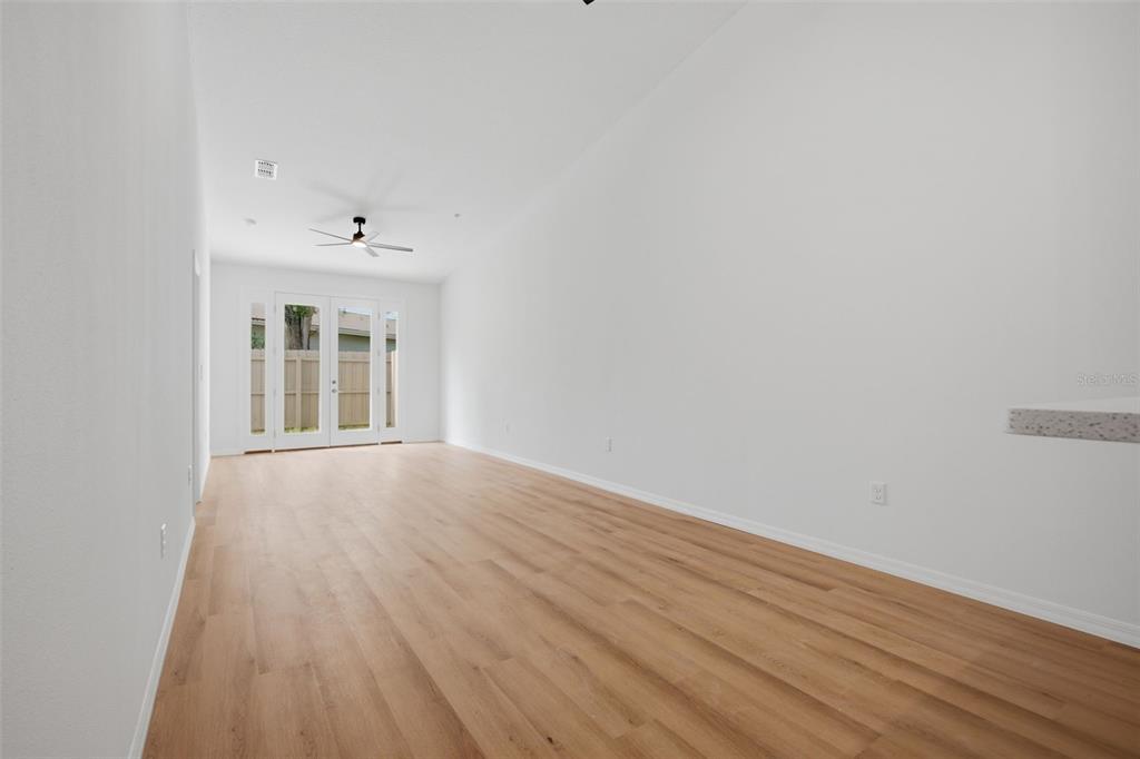 This rendering shows a dining area with a round table and chairs near a kitchen — 1411 OAK PL UNIT B, APOPKA, FL