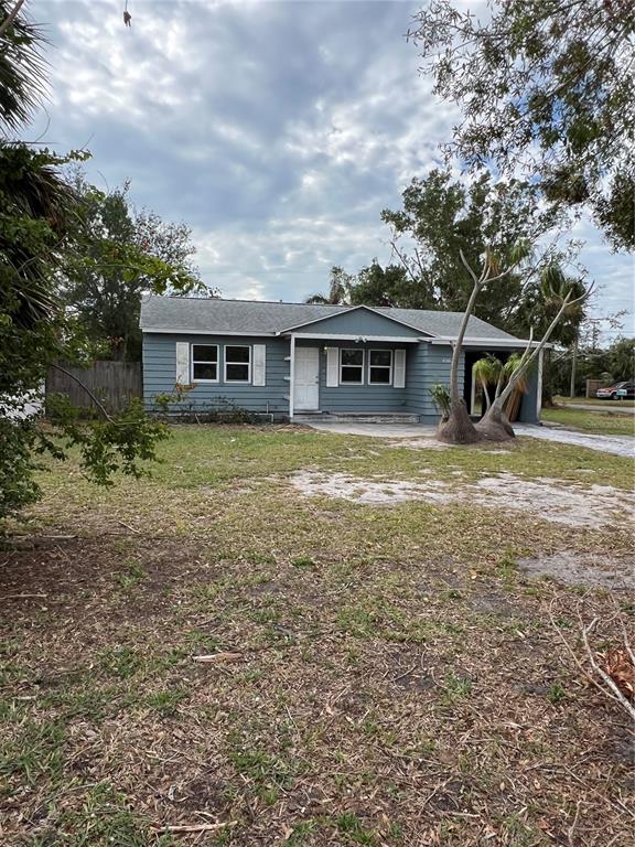 A single-story blue house with a white front door and a side carport — 2106 MAGNOLIA STREET, SARASOTA, FL