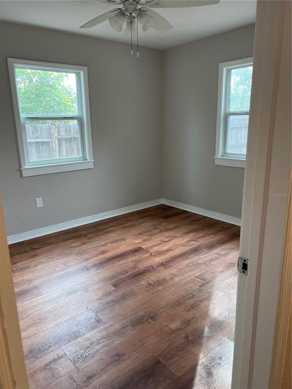 An empty bedroom features light gray walls, dark wood-look flooring, and a ceiling fan — 2106 MAGNOLIA STREET, SARASOTA, FL