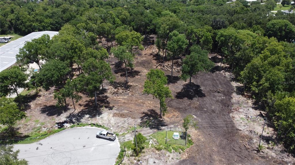 An aerial view shows a partially cleared wooded lot adjacent to a paved cul-de-sac — 843 GATEPARK DRIVE, DAYTONA BEACH, FL