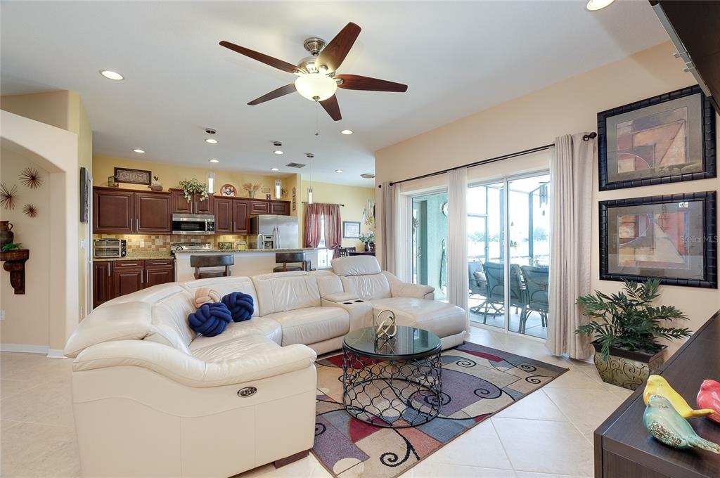 An aerial view shows a suburban house with a green garage facing a large lake — 7830 113TH AVENUE E, PARRISH, FL