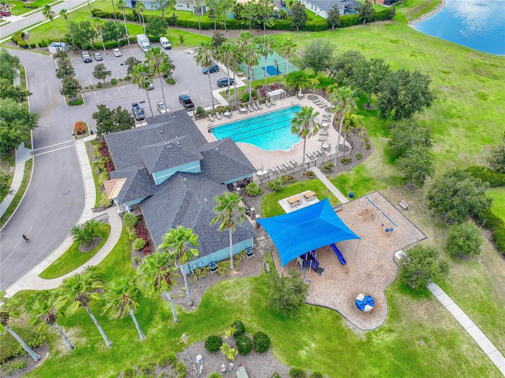 A single-story house features a green garage, stone facade, and a landscaped front yard — 7830 113TH AVENUE E, PARRISH, FL