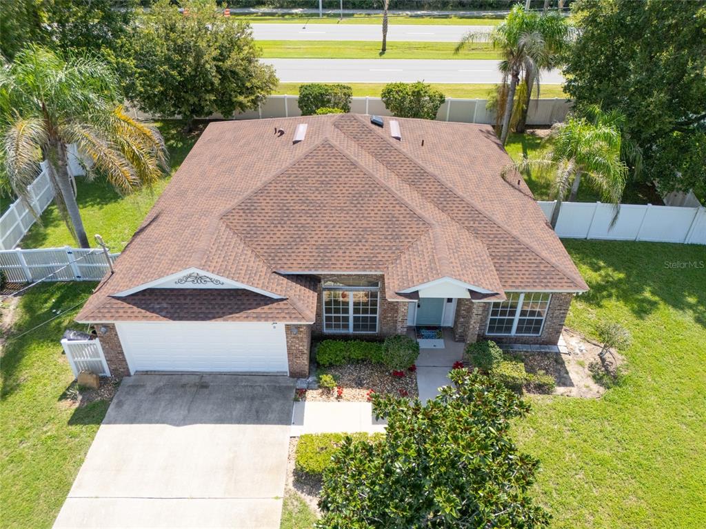 An aerial view shows a single-story brick house with a brown shingled roof and driveway — 22 EMERSON DRIVE, PALM COAST, FL